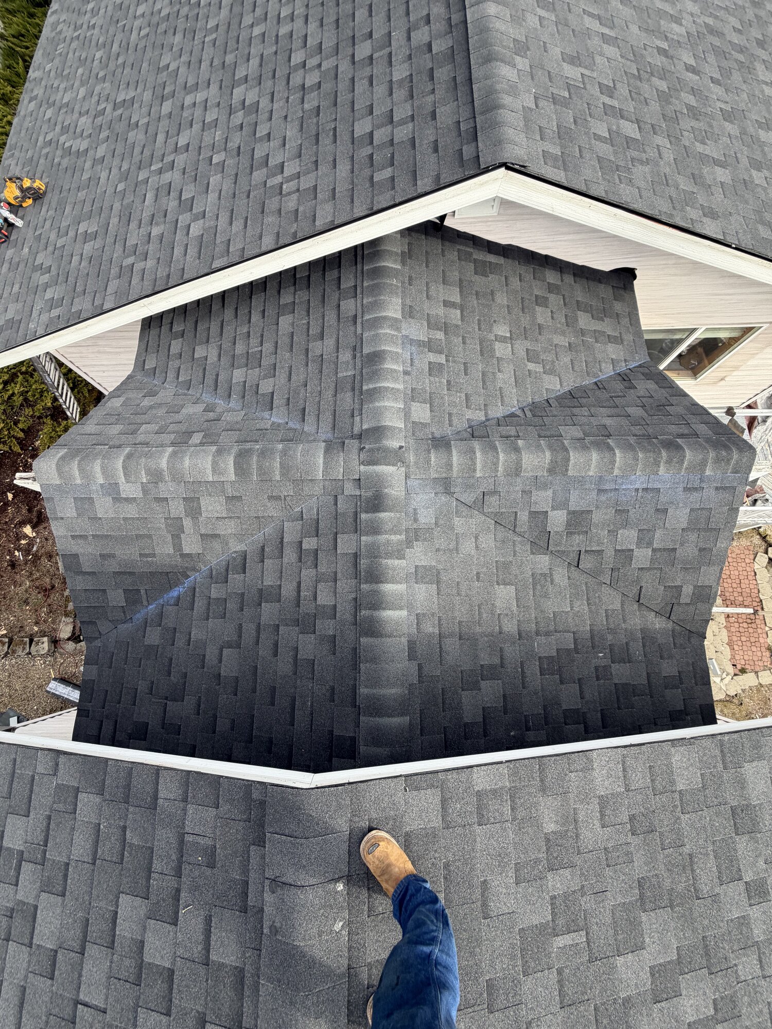 Roofing Rehab crew installing synthetic underlayment on a new roof